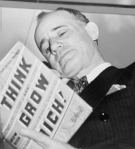 Napoleon Hill holding book 1937" by New York World-Telegram and the Sun Newspaper staff photographer.